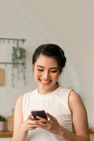 Customer smiling and looking up from phone after completing an efficiency purchase.